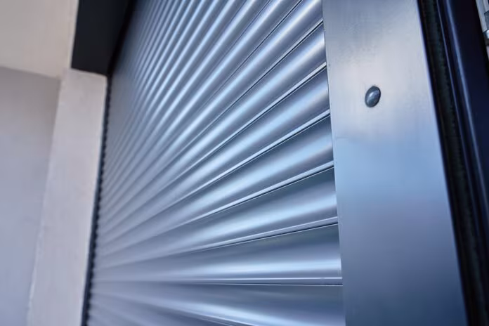 Modern window with roller shutter closing on house exterior